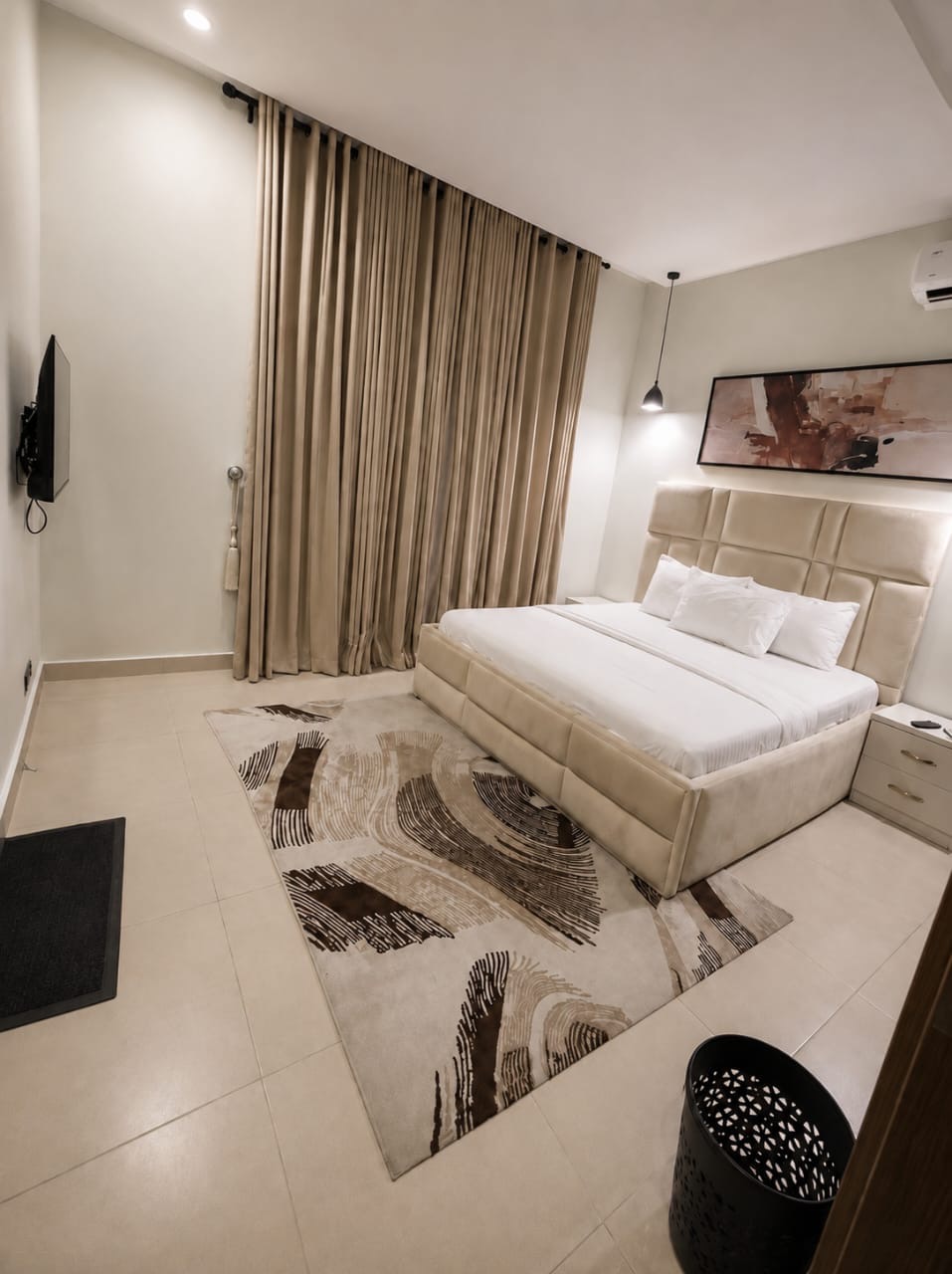 Cream furnished bedroom with floor-to-ceiling curtains
